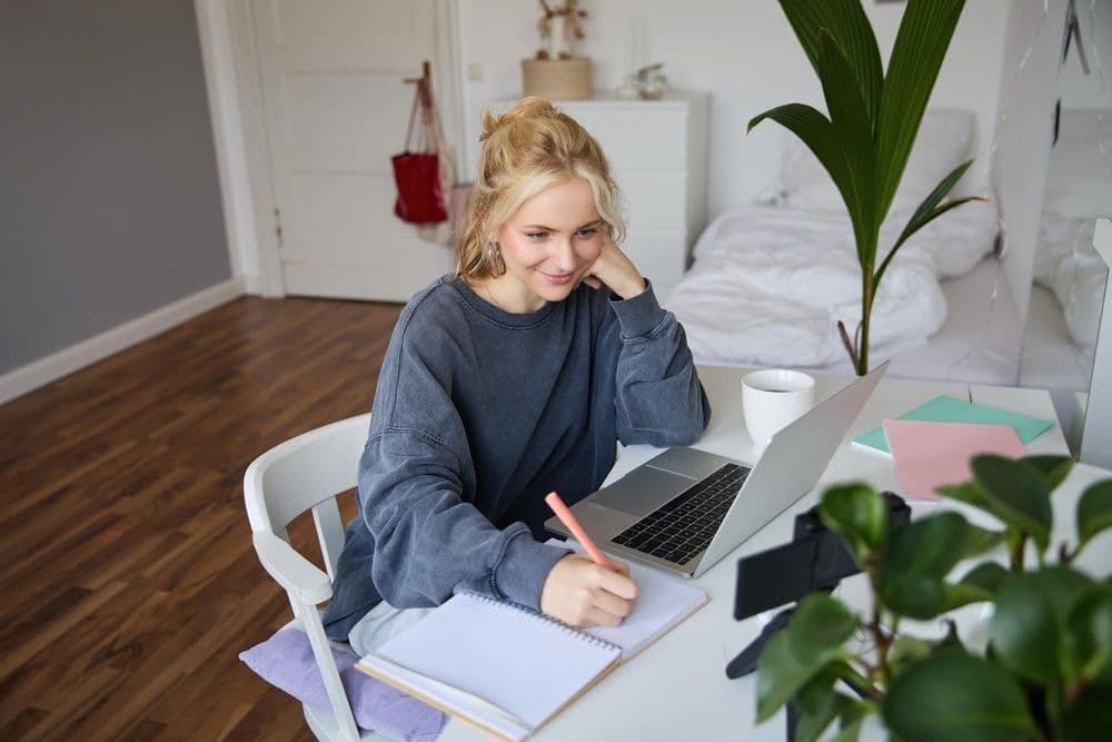 portrait-smiling-beautiful-blond-woman-writing-down-notes-doing-homework-studying-from-home-doing_1258-254363.jpg