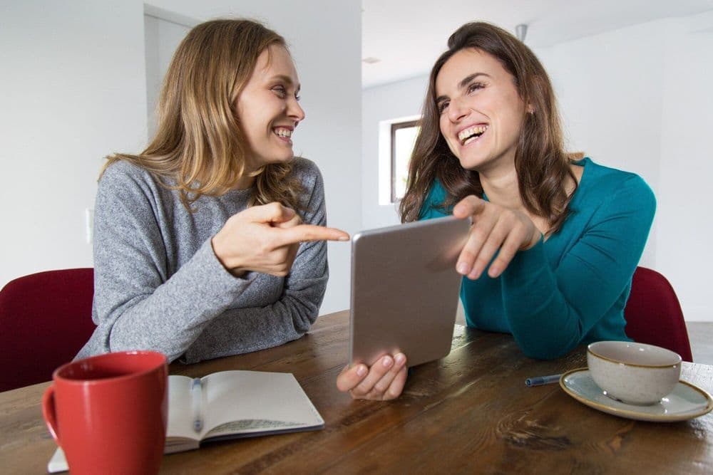 two-female-friends-discussing-funny-news_1262-18750